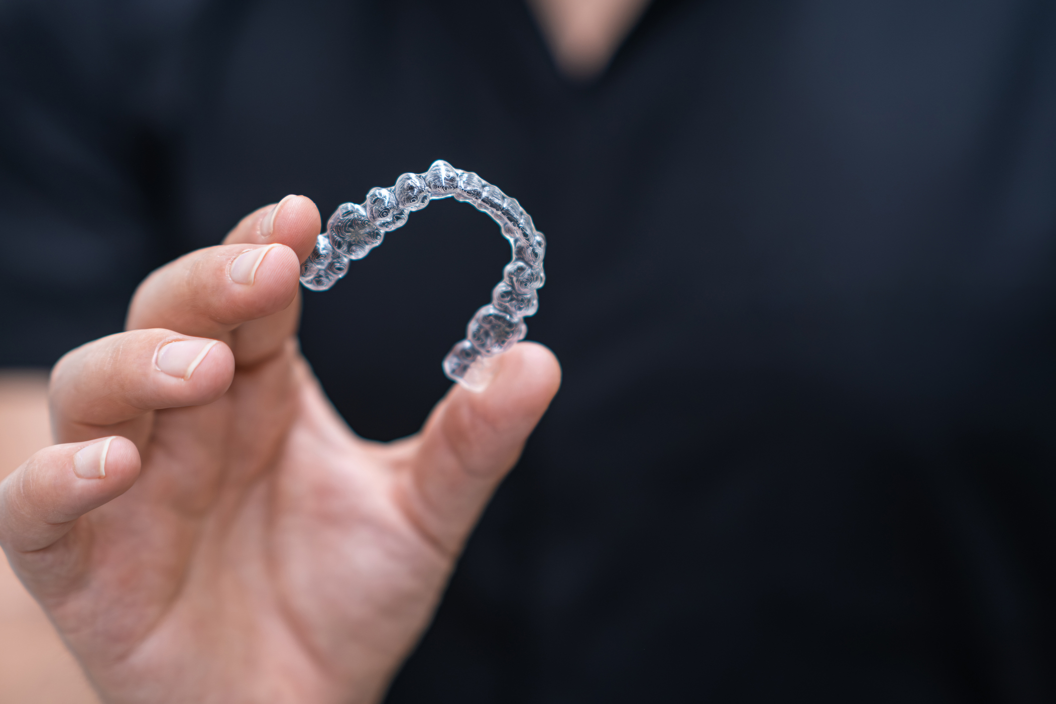 Dentist holding clear aligners
